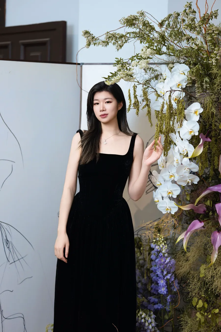 Yiran Wang beside a floral arrangement